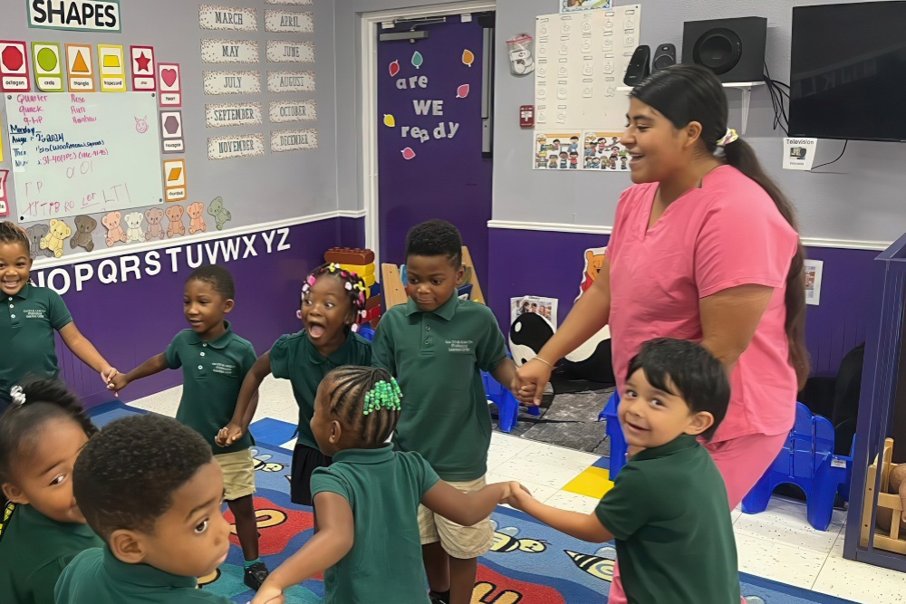 Happy kids wearing neat uniforms having fun with teacher